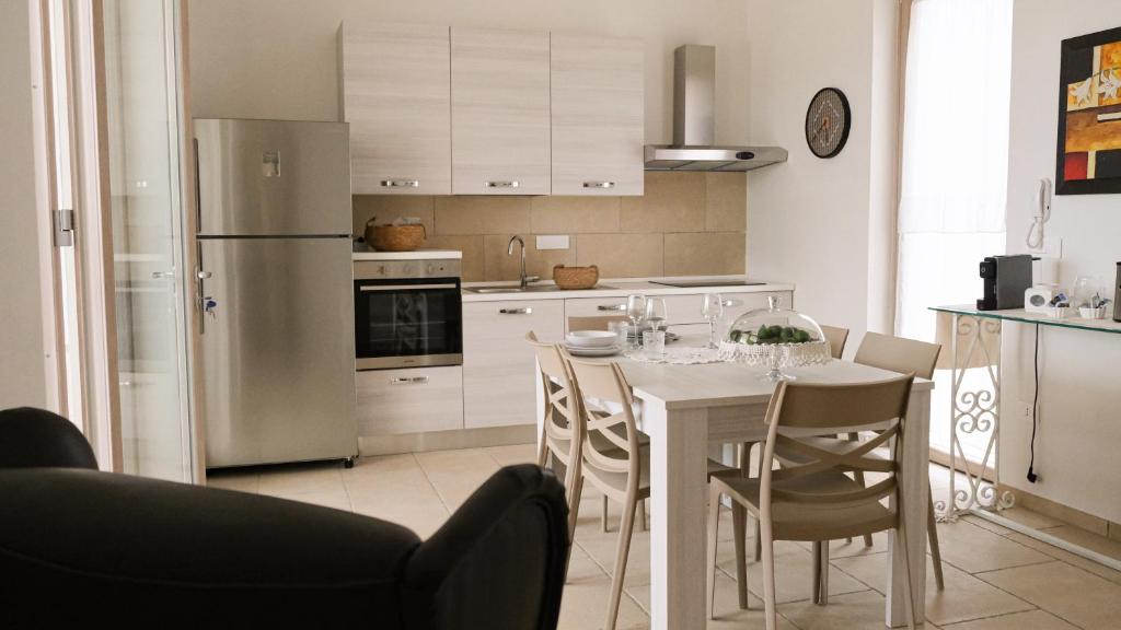 une cuisine avec une table avec des chaises et un réfrigérateur dans l'établissement Villa Geco, à Specchiolla 29 autres photos