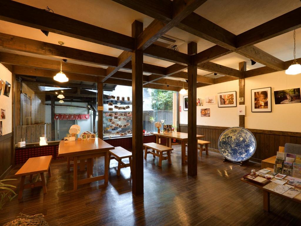 un restaurant avec des tables et des chaises en bois et une grande salle dans l'établissement Kannawa Yunoka, à Beppu