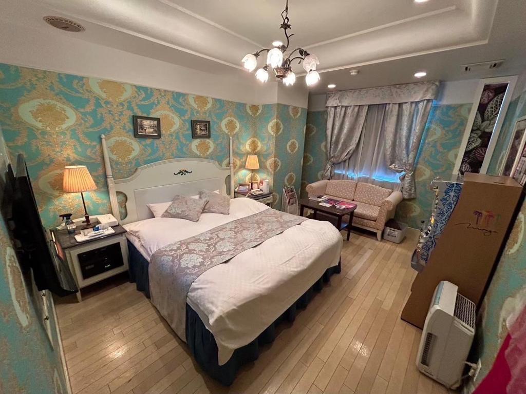 - une chambre avec un grand lit, un canapé et une chaise dans l'établissement HOTEL D-CUBE 明石店, à Higashi-futami