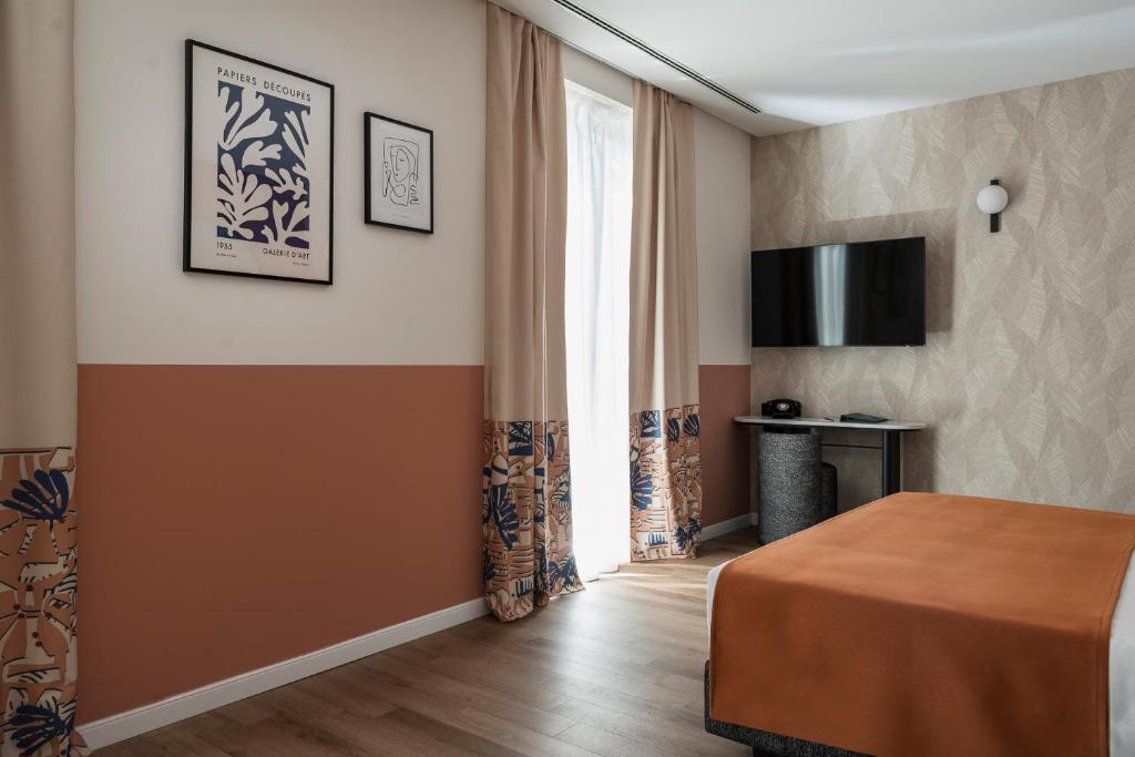 une chambre d'hôtel avec un lit et une télévision dans l'établissement DuoMo Hotel, à Rimini