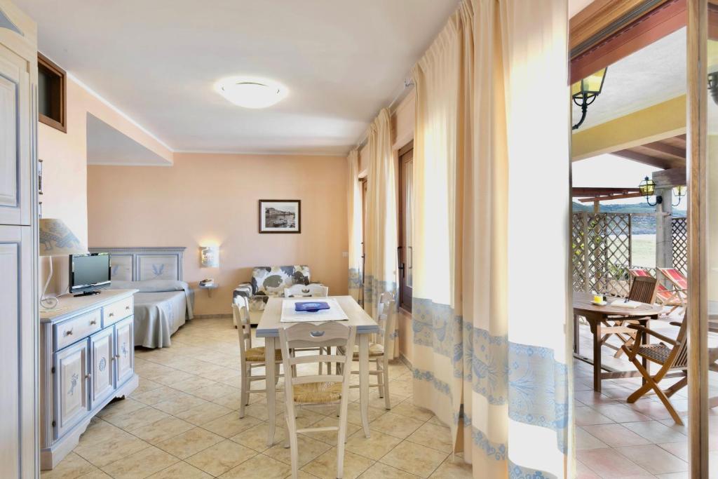 une cuisine et un salon avec une table et des chaises dans l'établissement Residence with private beach in Bosa Marina just 100 meters from the sea, à Bosa Marina