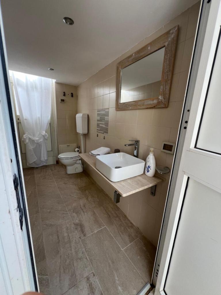 une salle de bain avec un lavabo, des toilettes et un miroir dans l'établissement Villa Losanna, à Mondello 54 autres photos