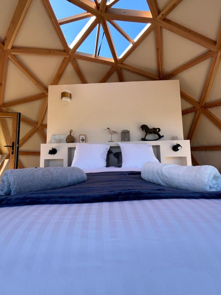 - une chambre avec un grand lit dans une tente dans l'établissement Dôme géodésique - Baie de Somme, à Favières