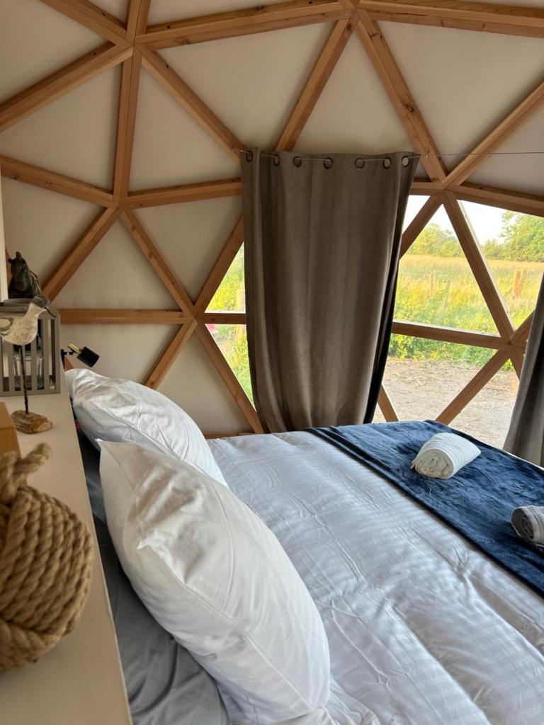 un lit dans une chambre avec une fenêtre dans l'établissement Dôme géodésique - Baie de Somme, à Favières