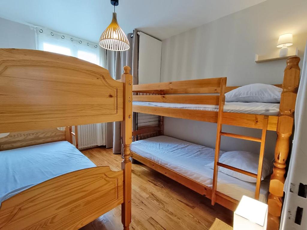 une chambre avec deux lits superposés et une lampe dans l'établissement L'appart du Maupas, T3, wifi, parking, à Luchon