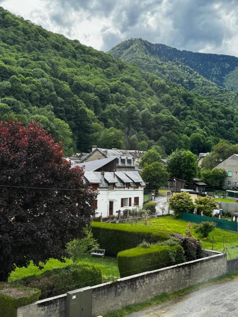 une vue d'un village avec des montagnes en arrière-plan dans l'établissement L'appart du Maupas, T3, wifi, parking, à Luchon