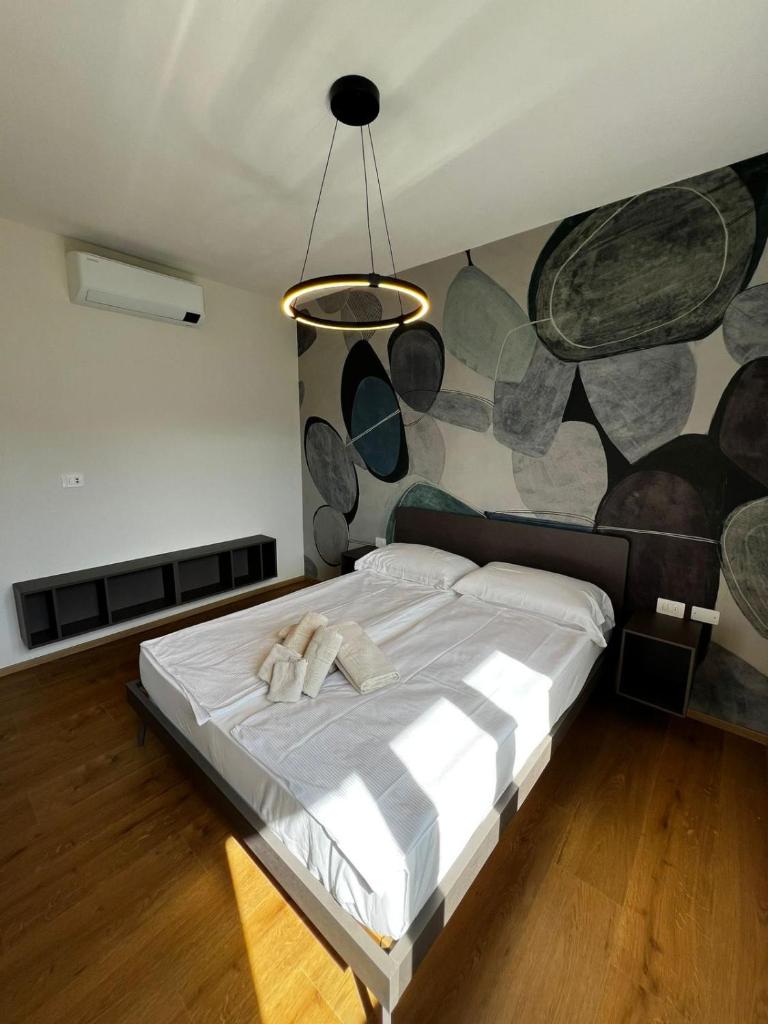 une chambre avec un grand lit avec une fresque sur le mur dans l'établissement Residence Garden, à Cannobio 19 autres photos