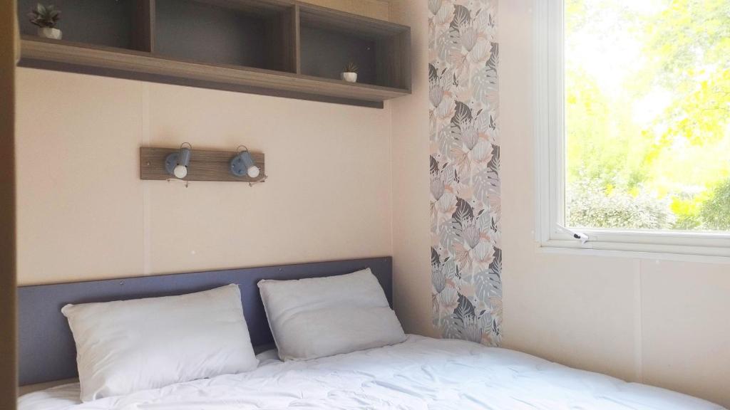 - un lit avec deux oreillers dans une chambre dotée d'une fenêtre dans l'établissement Mobil Home vue sur le lac dans un camping 4 étoiles à Cadenet, à Cadenet 20 autres photos