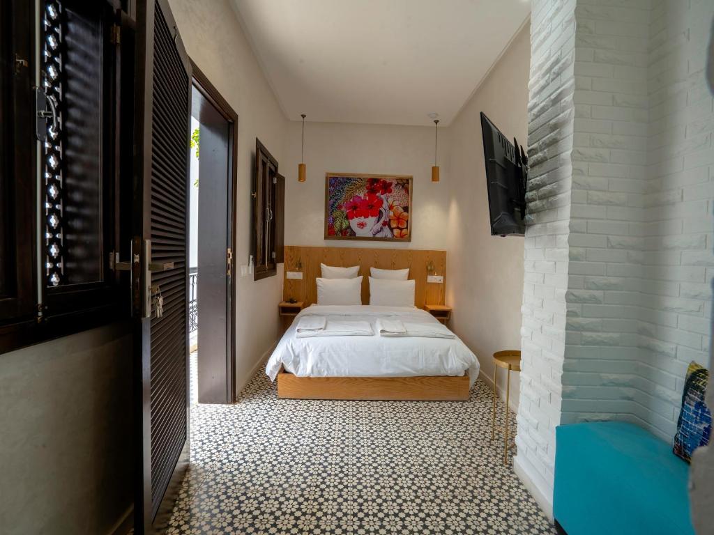 une chambre avec un lit et une télévision dans une pièce dans l'établissement MAISON SOLANEOS, à Marrakech