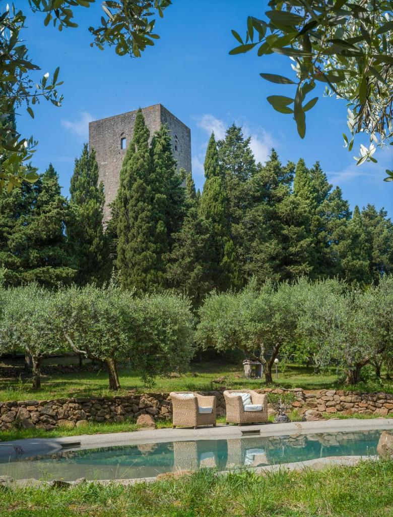 un bâtiment au milieu des arbres avec une piscine dans l'établissement Torre dei Belforti, à Montecatini Val di Cecina