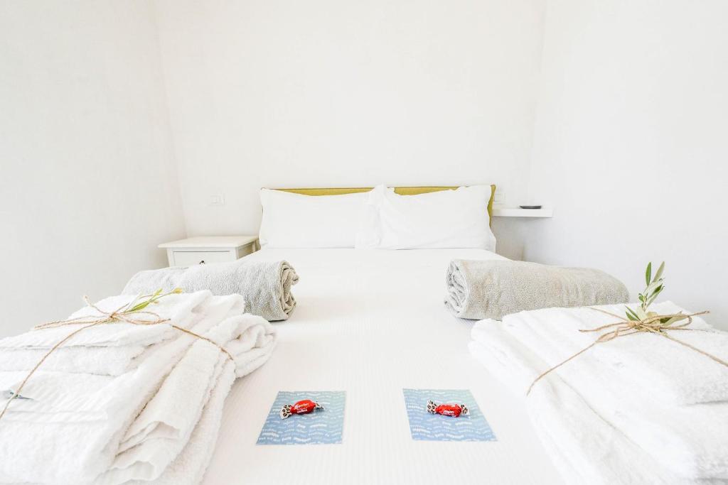 une chambre blanche avec deux lits avec serviettes dans l'établissement Trullo White Dream con Piscina, à Ostuni 32 autres photos