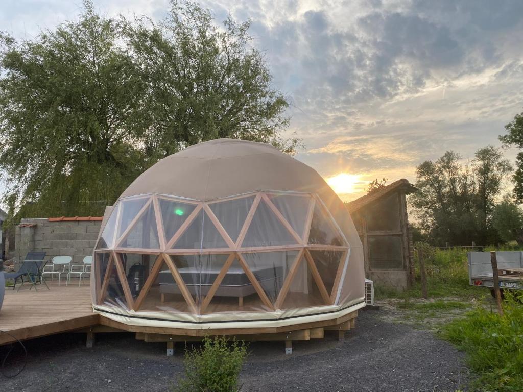 une tente en forme de dôme assise sur une terrasse en bois dans l'établissement Dôme géodésique - Baie de Somme, à Favières