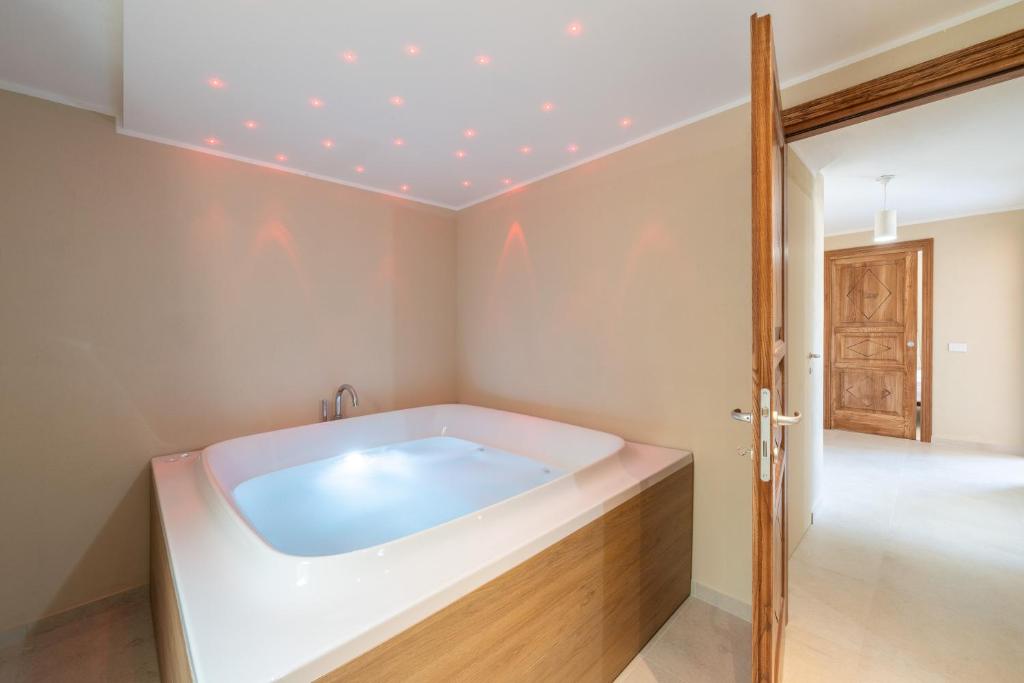 Cette chambre comprend une salle de bains pourvue d'une grande baignoire. dans l'établissement Villachiadream, à Chia