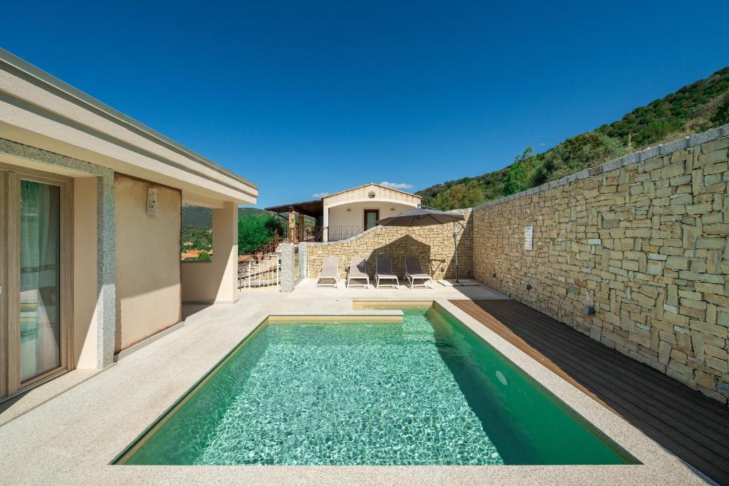 une piscine devant une maison avec un mur en pierre dans l'établissement Villachiadream, à Chia