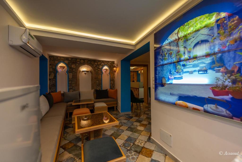 - un salon avec une grande télévision murale dans l'établissement Dar Kisania, à Chefchaouen