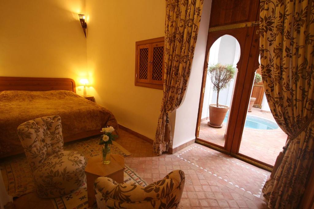 - une chambre avec un lit et une porte donnant sur une cour dans l'établissement Riad Chameau FDC Hôtel SPA, à Marrakech