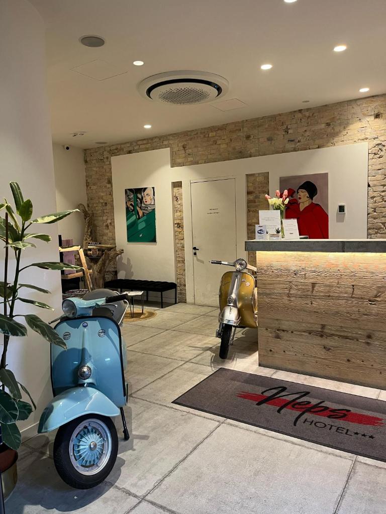 une pièce avec un scooter bleu garé dans une pièce dans l'établissement Hotel Neps, à Lido di Jesolo