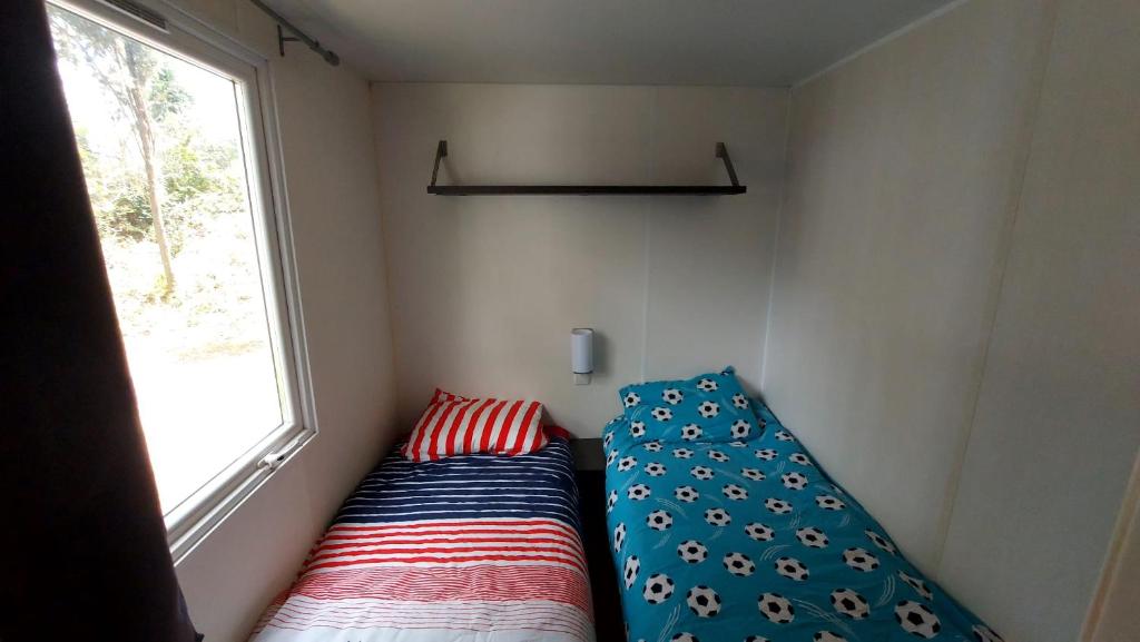 un lit dans une petite pièce avec une fenêtre dans l'établissement camping marvilla les 7 fonds, à Agde 1 autre photo