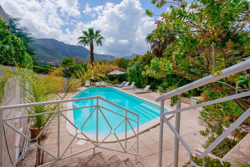 une piscine sur un balcon avec des montagnes en arrière-plan dans l'établissement Villa Ferrara Sardegna, à Capoterra