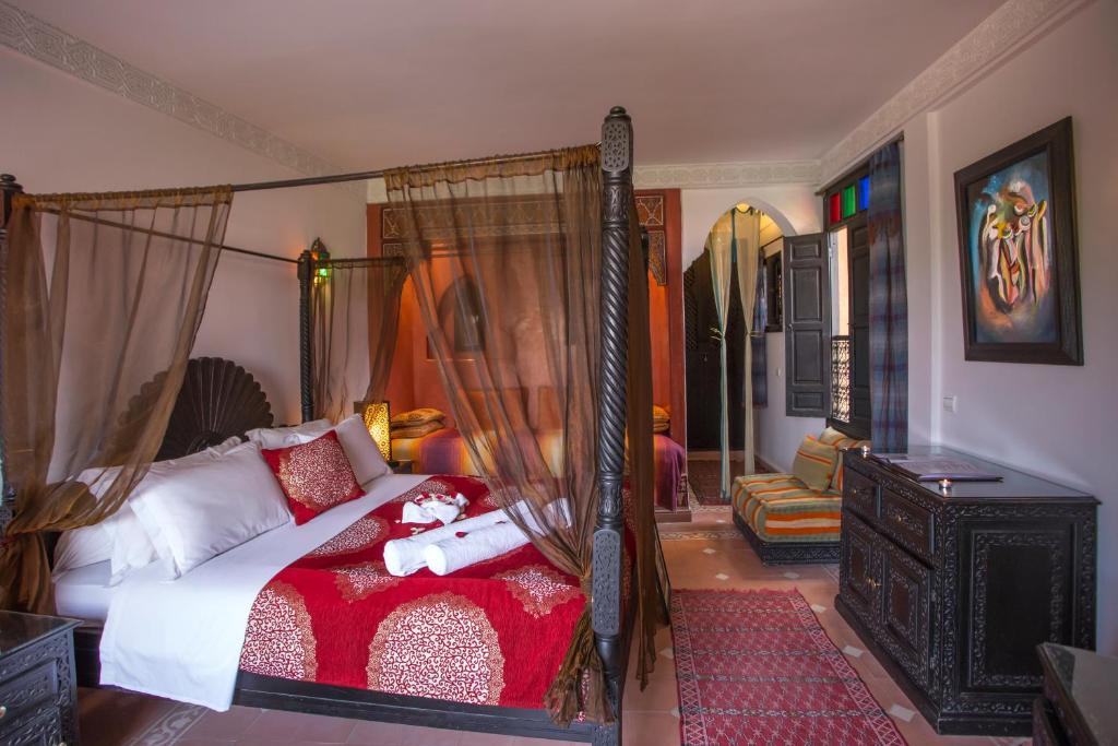 - une chambre avec un lit à baldaquin et une couverture rouge dans l'établissement Riad Jnane Mogador, à Marrakech