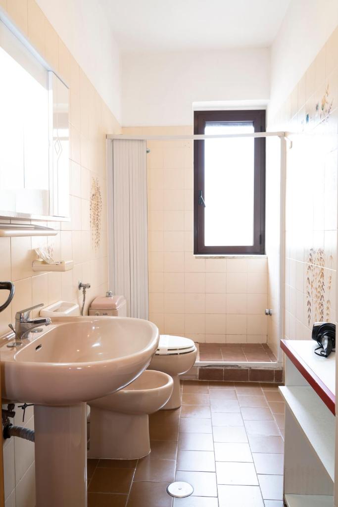 une salle de bain blanche avec un lavabo et des toilettes dans l'établissement Jolly Residence, à Marina di Camerota