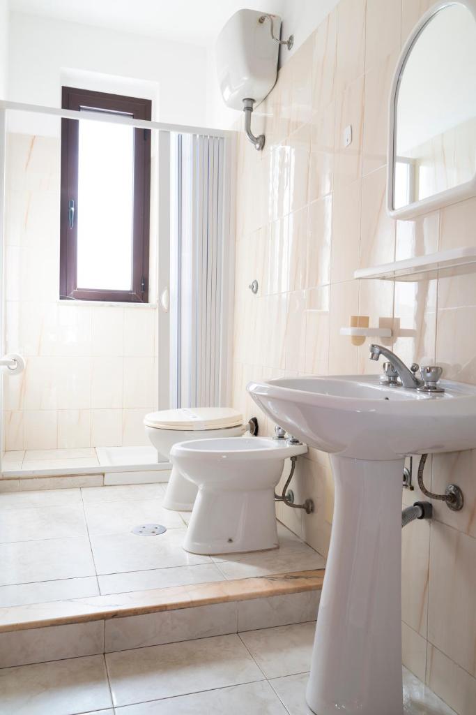 une salle de bain blanche avec un lavabo et des toilettes dans l'établissement Jolly Residence, à Marina di Camerota 47 autres photos