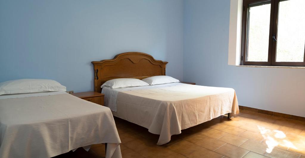 une chambre avec deux lits et une fenêtre dans l'établissement Jolly Residence, à Marina di Camerota