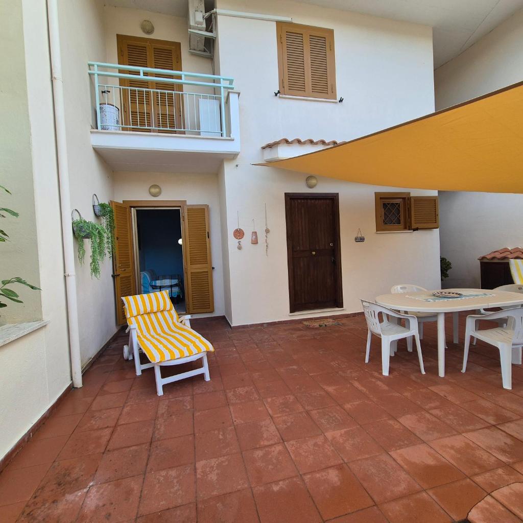 un patio avec une table et des chaises et un bâtiment dans l'établissement Villa Sabaudia, à Sabaudia