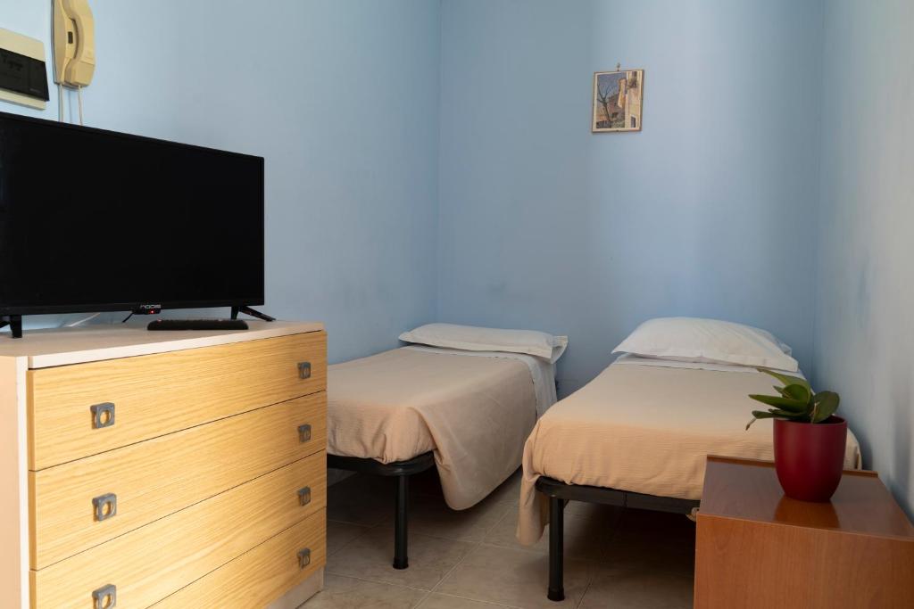 une chambre avec deux lits jumeaux et une télévision dans l'établissement Jolly Residence, à Marina di Camerota