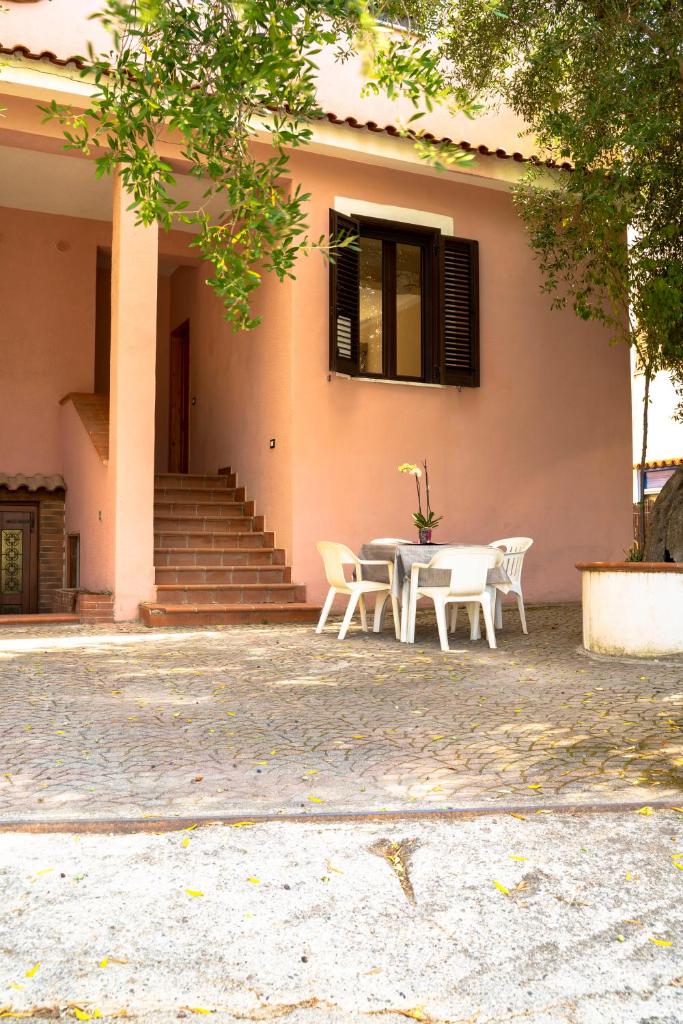 une table et des chaises devant une maison dans l'établissement Jolly Residence, à Marina di Camerota
