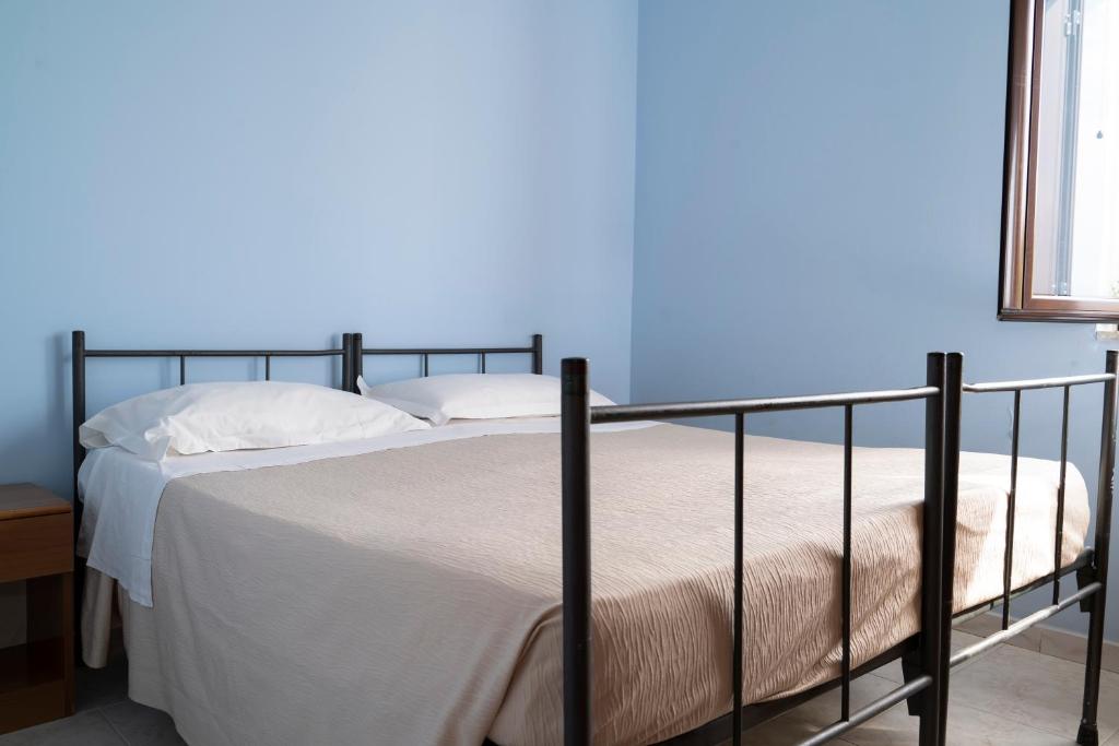 Ce lit se trouve dans une chambre dotée d'un mur bleu. dans l'établissement Jolly Residence, à Marina di Camerota