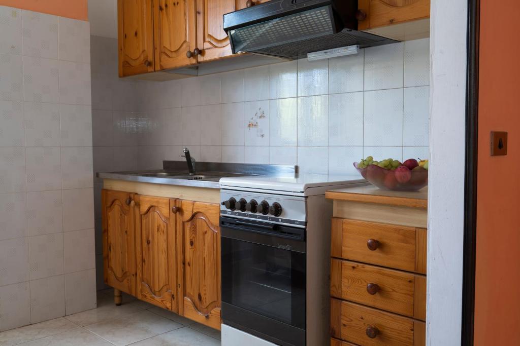 - une cuisine avec une cuisinière et un bol de fruits dans l'établissement Jolly Residence, à Marina di Camerota