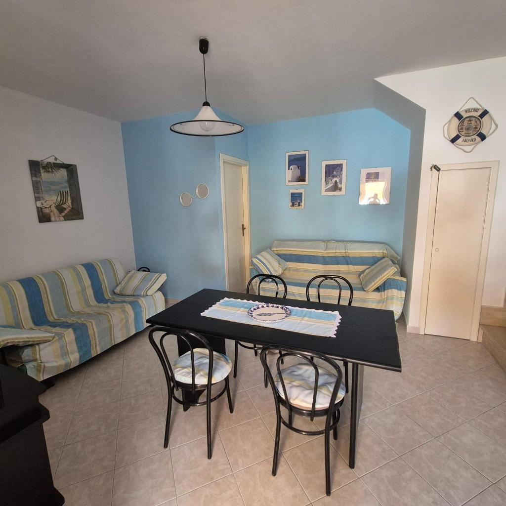 un salon avec une table, des chaises et un canapé dans l'établissement Villa Sabaudia, à Sabaudia