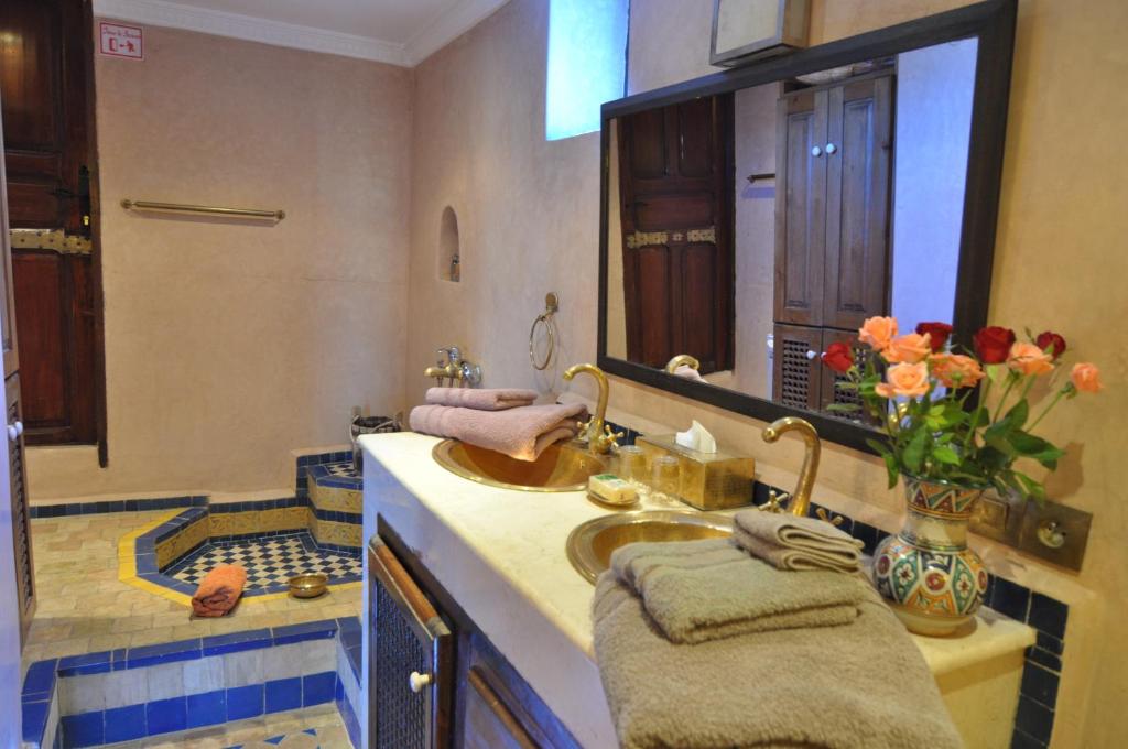 une salle de bain avec un lavabo et un grand miroir dans l'établissement Riad Adarissa, à Fès 37 autres photos