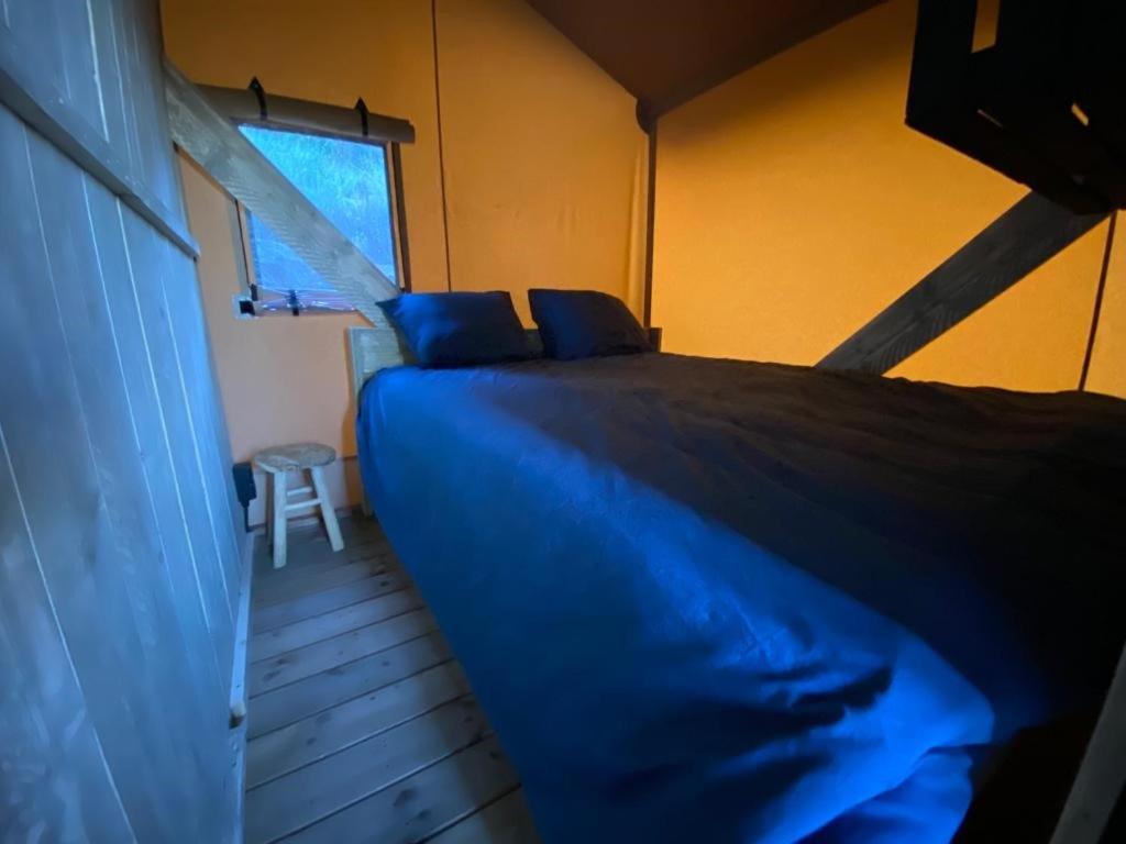 - un lit bleu dans une chambre avec fenêtre dans l'établissement DOMAINE DU CHENE, à Campagnan