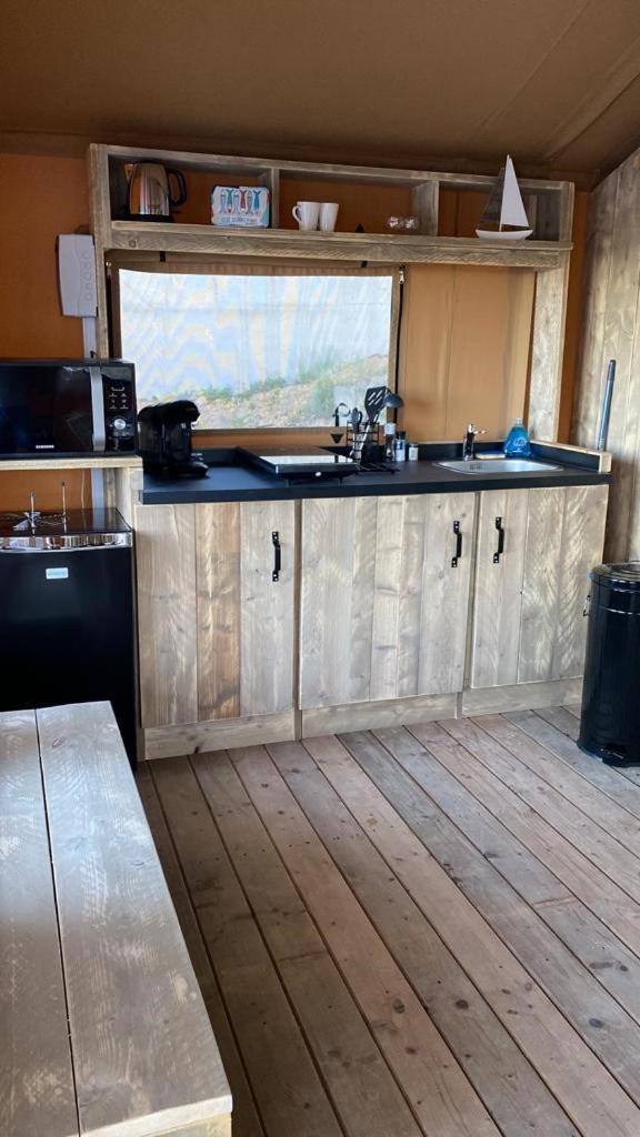 une cuisine avec des armoires en bois et un comptoir dans l'établissement DOMAINE DU CHENE, à Campagnan