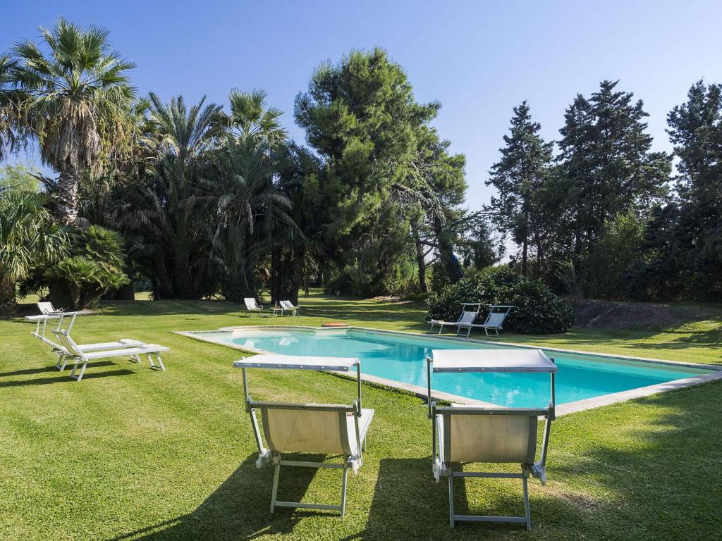 - une piscine avec deux chaises dans la cour dans l'établissement Villa Del Parco, à Agnone Bagni