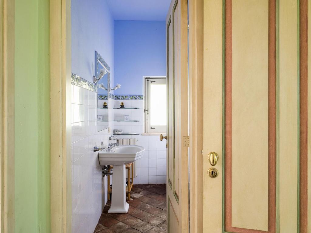 une salle de bain blanche avec un lavabo et un miroir dans l'établissement Villa Del Parco, à Agnone Bagni