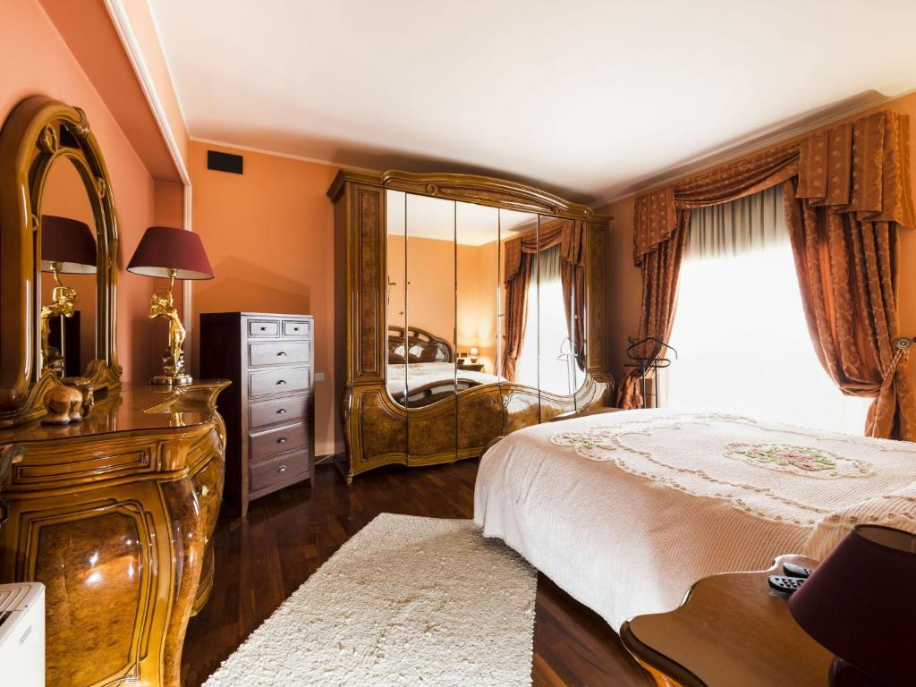 une chambre avec un lit, une commode et un miroir dans l'établissement Villa Ambra, à Trappitello 16 autres photos