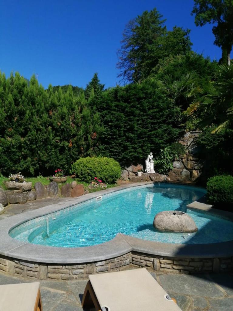 une piscine avec un rocher au milieu dans l'établissement Penthouse in the green with private pool and garden, à Portula