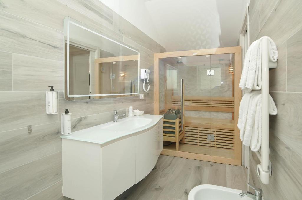 une salle de bain blanche avec un lavabo et des toilettes dans l'établissement Marina Suites & Apartments 4 stelle S, à Caorle