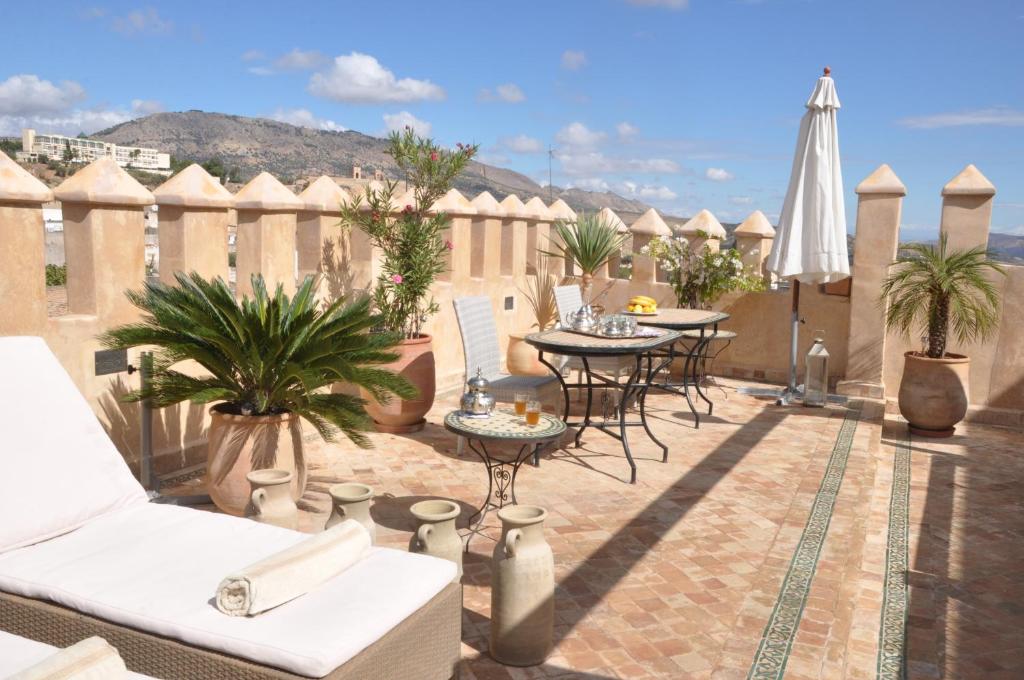 d'une terrasse avec des tables et des chaises et une clôture. dans l'établissement Riad Adarissa, à Fès
