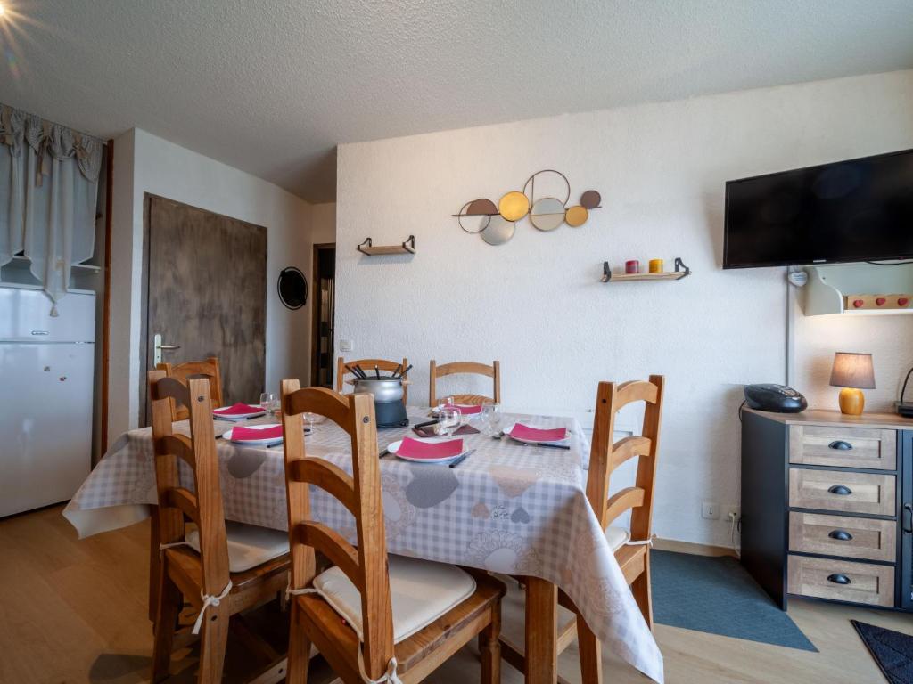 une salle à manger avec une table avec des chaises et une télévision dans l'établissement Apartment Bâtiment A-18 by Interhome, au Corbier