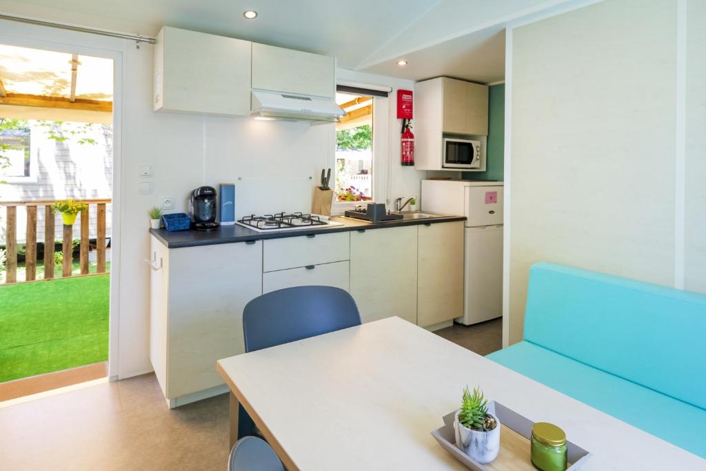 une cuisine et une salle à manger avec une table et des chaises dans l'établissement Mobilhome Capbreton, à Capbreton