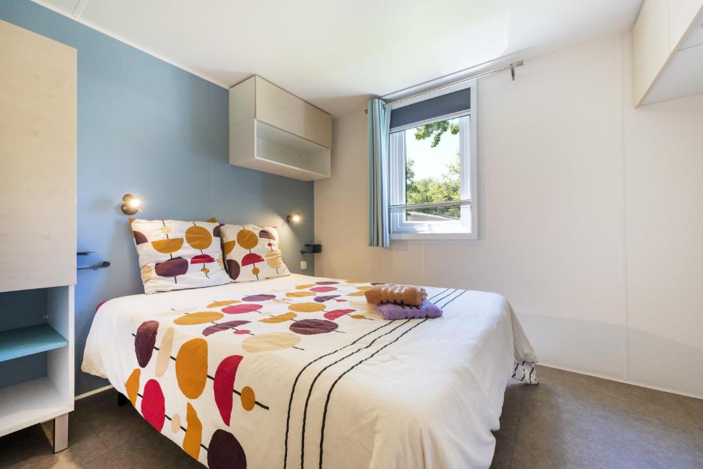 une chambre avec un lit et une fenêtre dans l'établissement Mobilhome Capbreton, à Capbreton