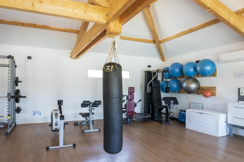 une salle de sport avec un sac de frappe dans une pièce avec des appareils d'exercice dans l'établissement camping les oyats, à Seignosse