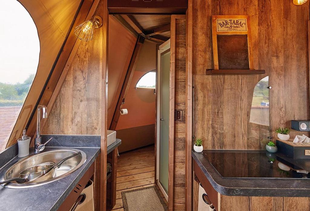 une salle de bain avec un lavabo et un miroir dans l'établissement Lodge Tipi, L'Indienne, à Arc-et-Senans