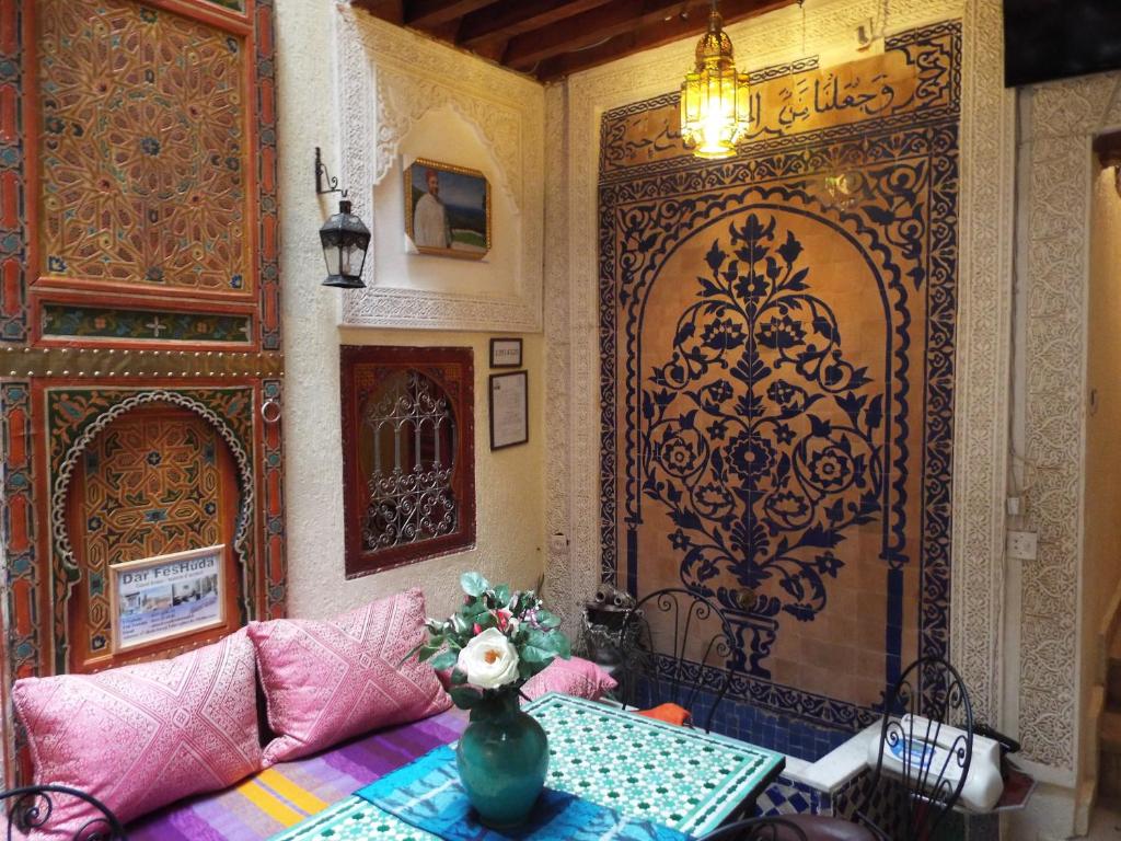 Cette chambre dispose d'une table et d'une grande porte. dans l'établissement Dar Fès Huda, à Fès