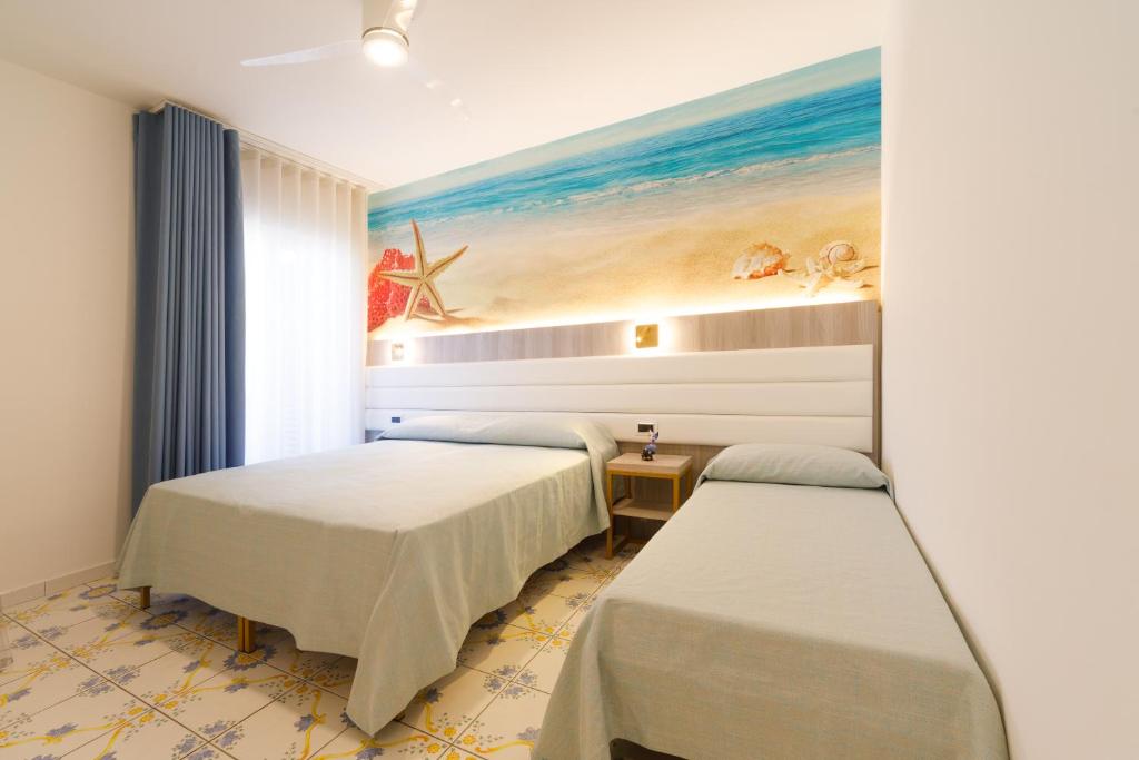 deux lits dans une chambre avec un tableau au mur dans l'établissement Villa Maredona, à Ascea