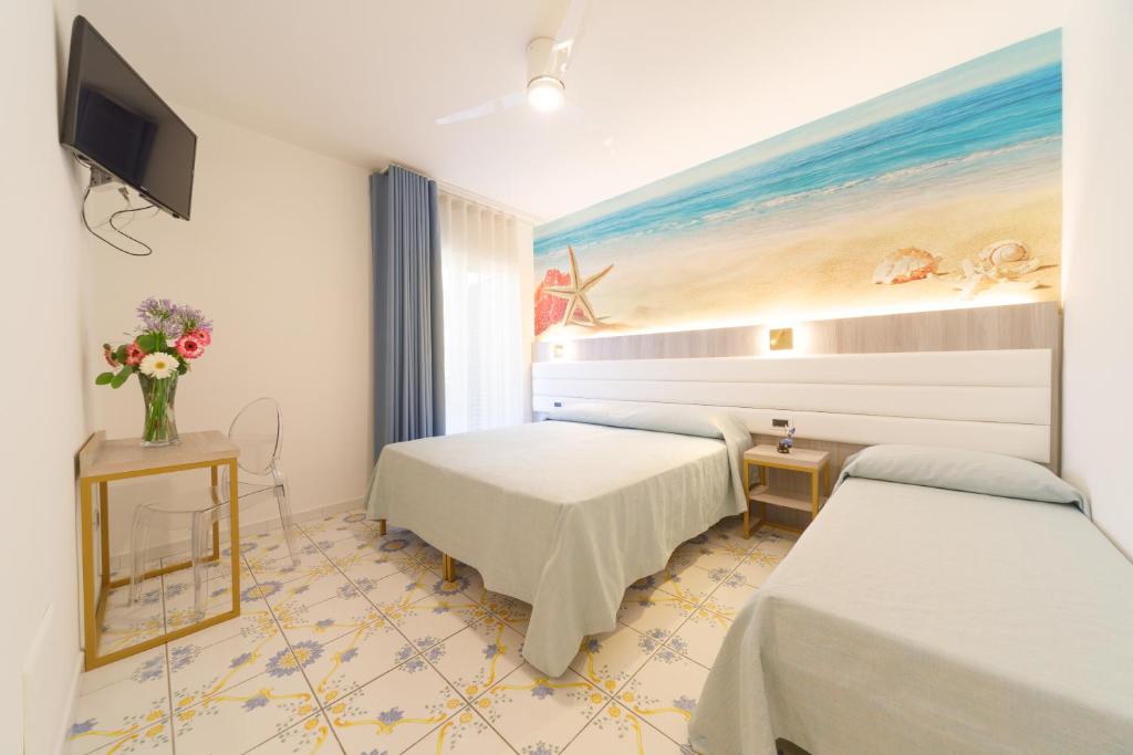 une chambre d'hôtel avec deux lits et une télévision dans l'établissement Villa Maredona, à Ascea 137 autres photos